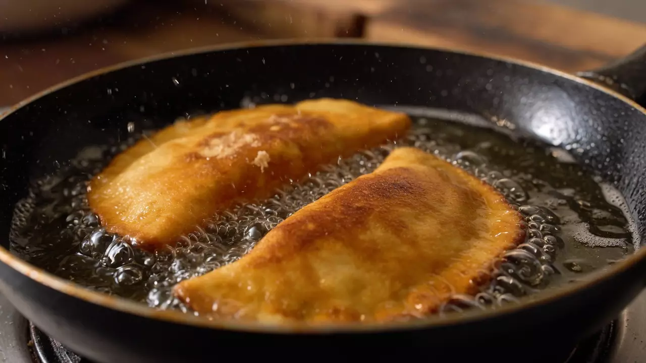 Чебуреки с мясом жарятся на сковороде